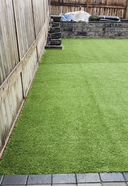 Vibrant green artificial turf installed for backyard sports and recreation area