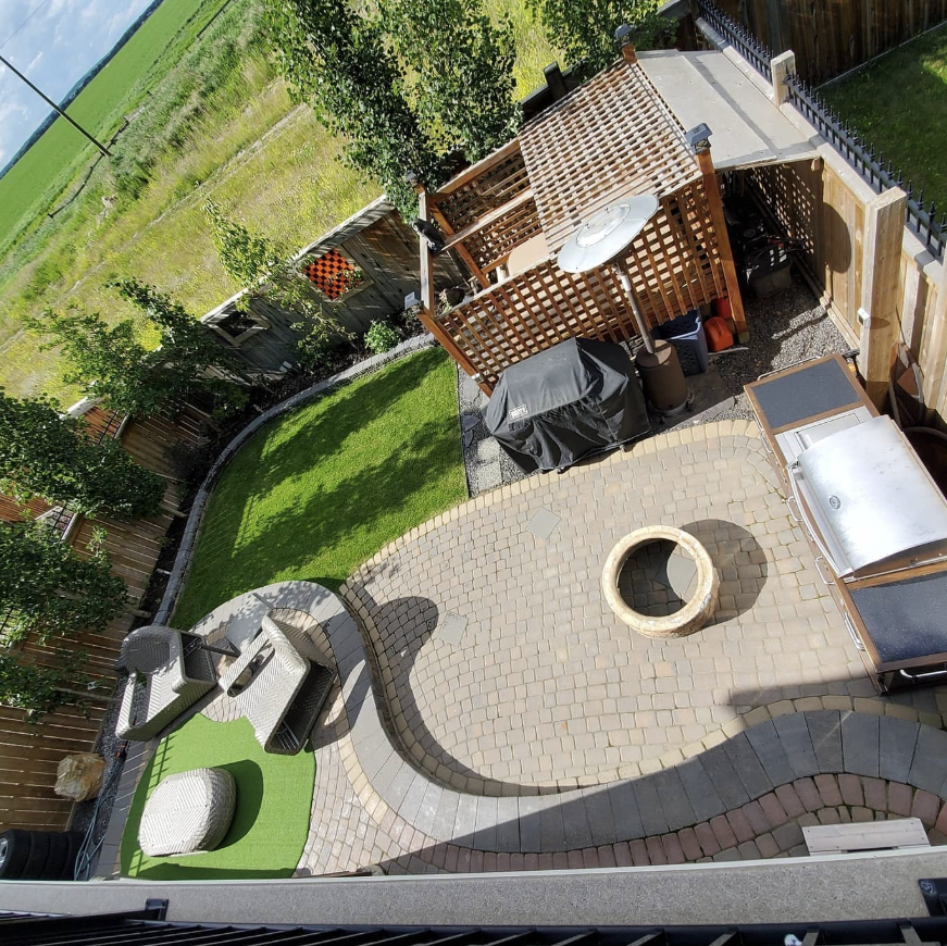 Custom designed natural stone patio with outdoor furniture in a Calgary backyard